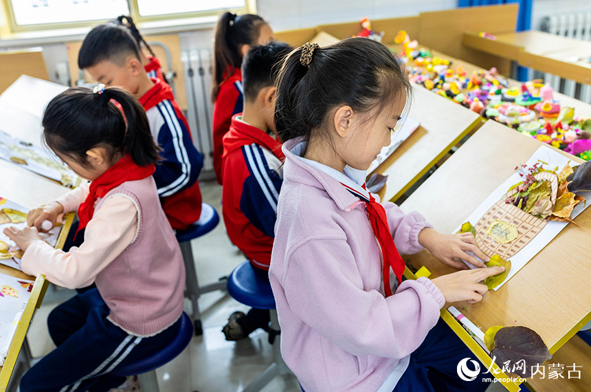 呼和浩特市玉泉区石东路小学学生在绘制创意树叶画。丁根厚摄