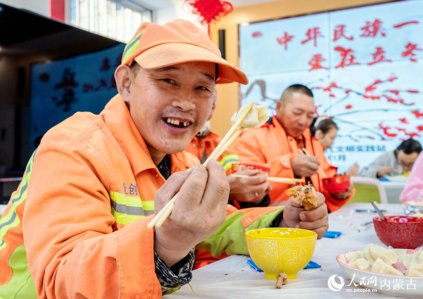 11月7日，环卫工人在呼和浩特市玉泉区清泉街社区迎立冬主题活动现场品尝立冬饺子。丁根厚摄