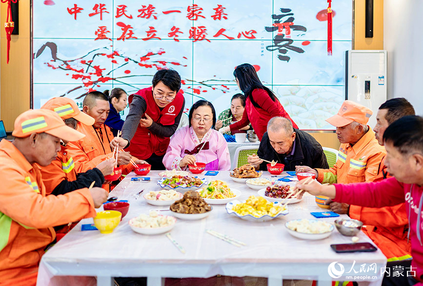 11月7日，环卫工人和社区居民在呼和浩特市玉泉区清泉街社区迎立冬主题活动现场品尝立冬饺子。丁根厚摄