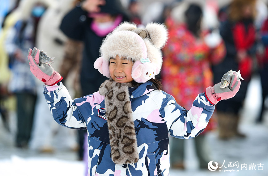 2024年12月22日，小朋友在黑山頭口岸景區冰釣體驗區展示捕獲的白魚。王正攝