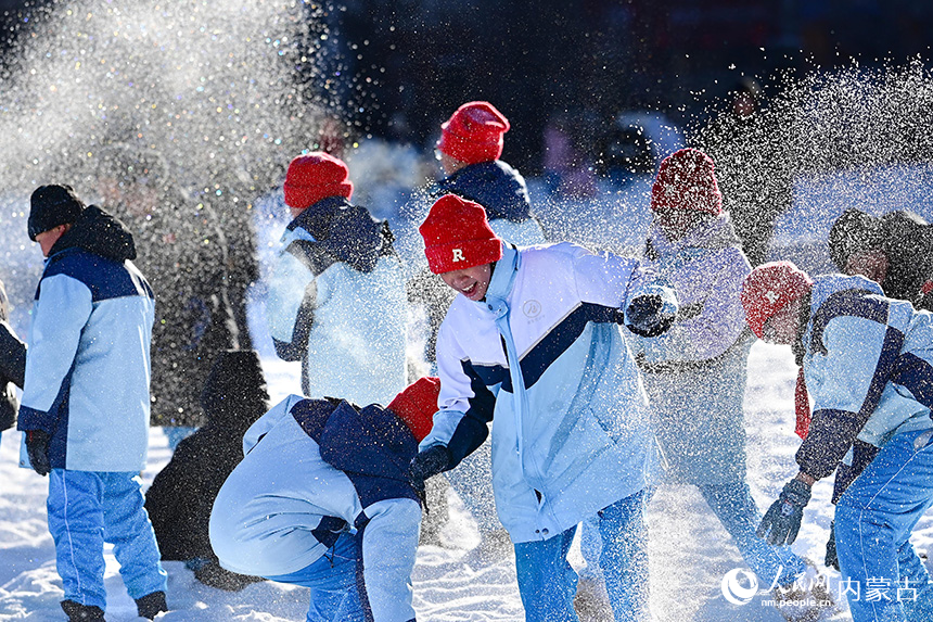 呼倫貝爾市海拉爾區健康街小學學生在校園冰雪嘉年華中戲雪。王正攝