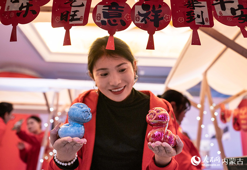 呼和浩特博物館，工作人員在景德鎮中國陶瓷博物館展位上展示生肖蛇文創產品。丁根厚攝
