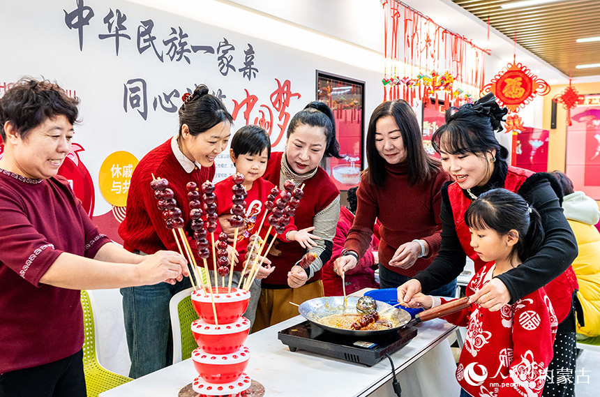 呼和浩特市玉泉區清泉街社區居民在臘八節活動現場制作糖葫蘆。丁根厚攝