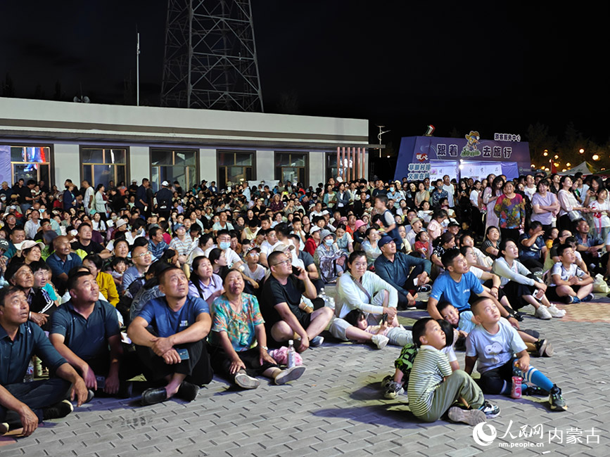 沿黄九省区农牧民排球邀请赛场地外，观众集体观看大屏转播。人民网记者 苗阳摄