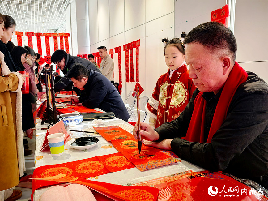 书法爱好者写春联、福字免费送给市民，迎接传统新春佳节。郝雪娇摄