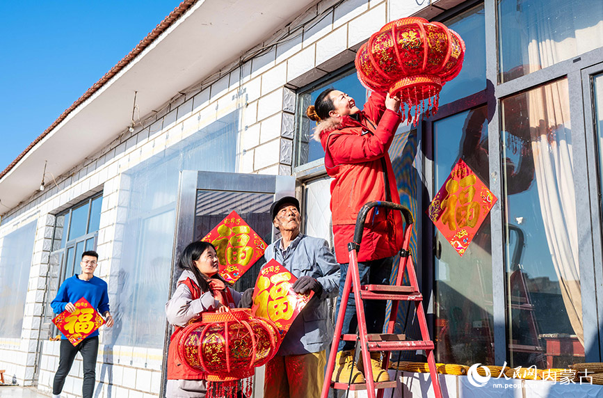 1月18日，志愿者在呼和浩特市玉泉区“三下乡”活动中入户为抗美援朝老兵赠送新春饰品。丁根厚摄