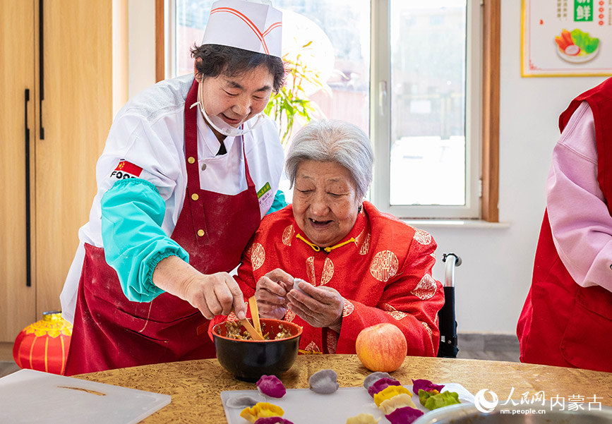 1月20日，工作人员与老人们在呼和浩特市玉泉区民政局迎新春主题活动现场一起包饺子。丁根厚摄