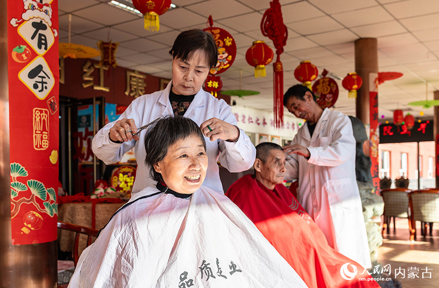 1月20日，工作人员在呼和浩特市玉泉区民政局迎新春主题活动现场为老人们理发。丁根厚摄