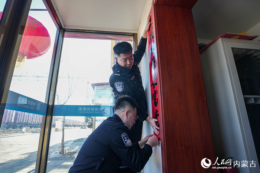 二连出入境边防检查站移民管理警察在单位张贴对联做着喜迎新春的准备。杨金烨摄