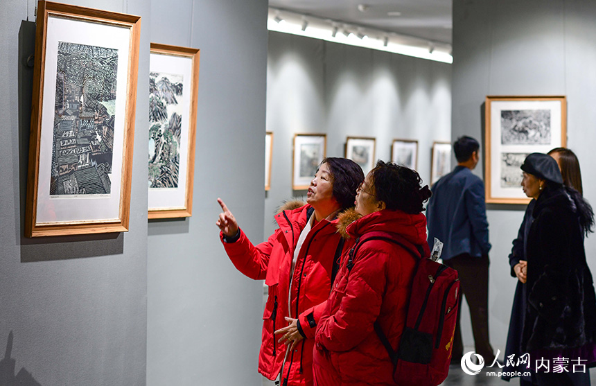 观众在鄂尔多斯市文化馆观赏陕西安康木板画展。王正摄