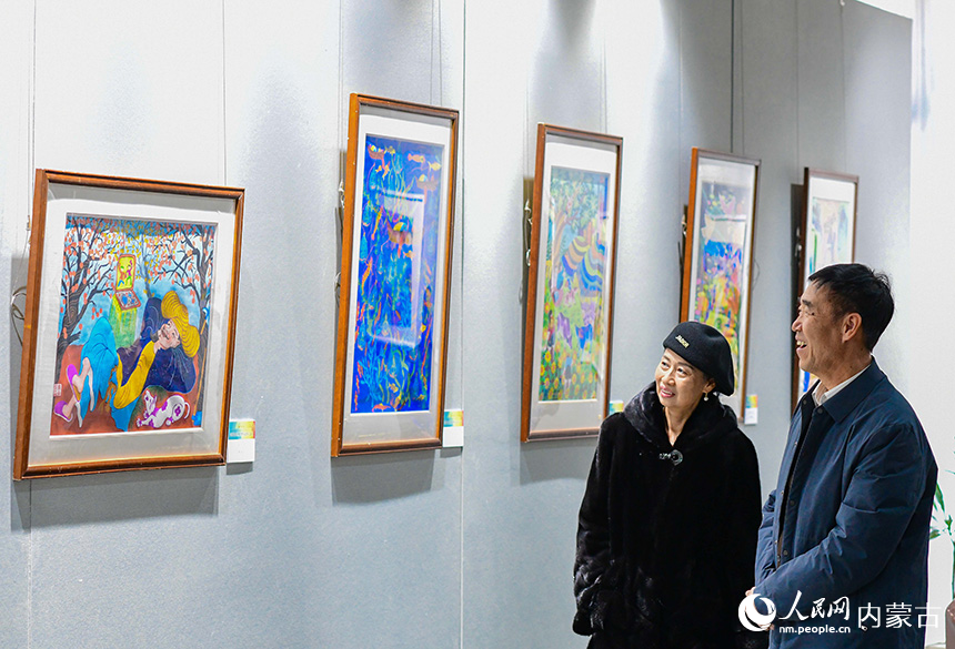 观众在鄂尔多斯市文化馆观赏云南农民画展。王正摄