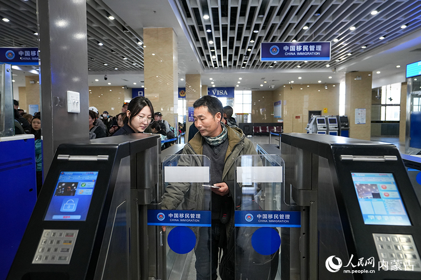 二連出入境邊防檢查站移民管理警察幫助旅客使用快捷通道通關。郭鵬杰攝