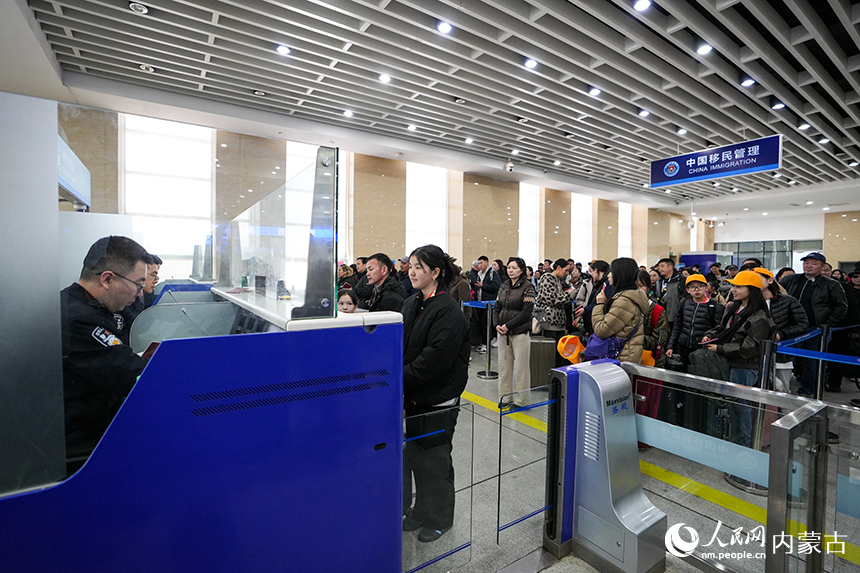 二連出入境邊防檢查站移民管理警察快速為旅客辦理通關手續。郭鵬杰攝