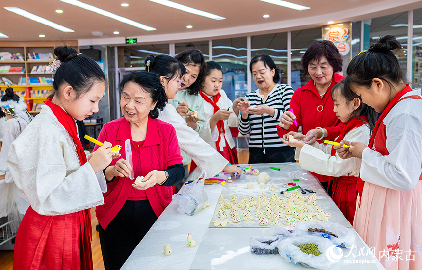 呼和浩特市玉泉区通顺街小学的少先队员们在民间艺人的指导下学习制作当地清明时节的特色面塑“寒燕”。丁根厚摄