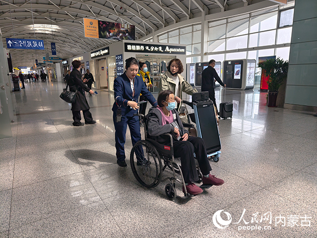 呼和浩特白塔机场工作人员服务旅客。张如意摄
