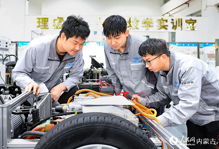 内蒙古机电职业技术学院学生在新能源汽车维护保养实训基地参加实训学习。王正摄