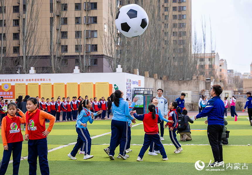 呼和浩特市玉泉區石東路小學女足隊員在女孩足球節活動現場參加趣味足球游戲。丁根厚攝