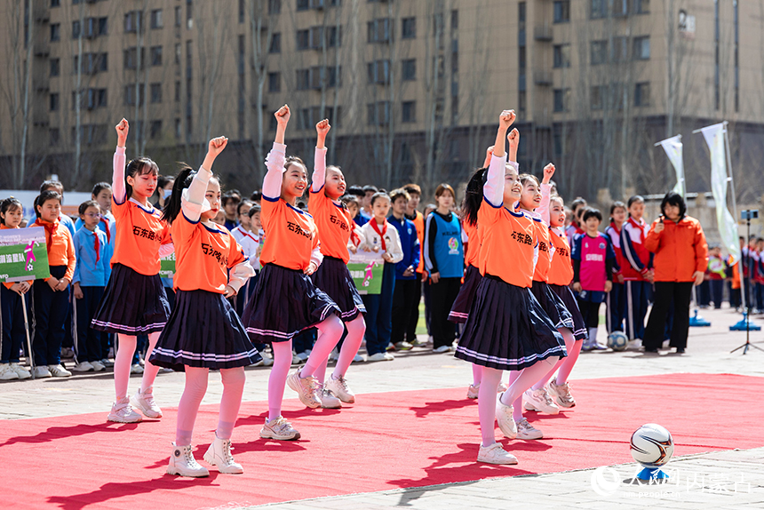 呼和浩特市玉泉區石東路小學學生在女孩足球節活動現場表演足球啦啦操。丁根厚攝