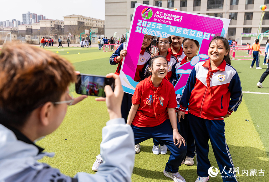 呼和浩特市玉泉區石東路小學女足隊員在女孩足球節活動現場留影。丁根厚攝