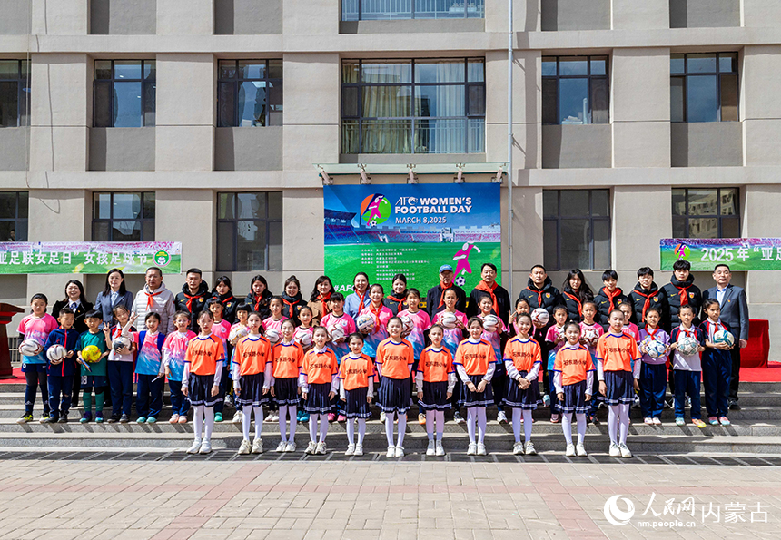 中國國家女子五人制足球隊教練員、隊員與呼和浩特市玉泉區石東路小學女足隊員在活動現場留影。丁根厚攝