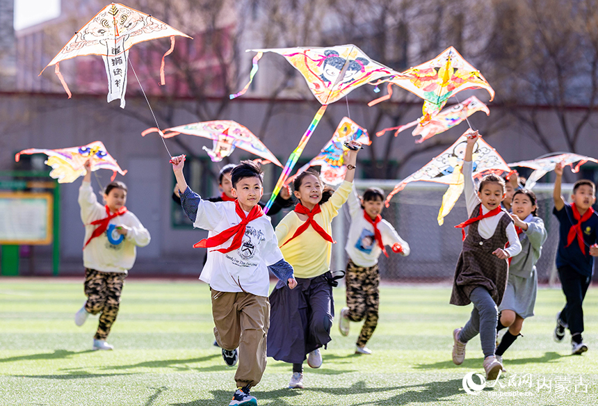 呼和浩特市玉泉區五塔寺東街小學學生在操場上放飛手繪風箏。丁根厚攝