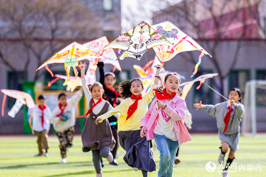 呼和浩特市玉泉區五塔寺東街小學學生在操場上放飛手繪風箏。丁根厚攝