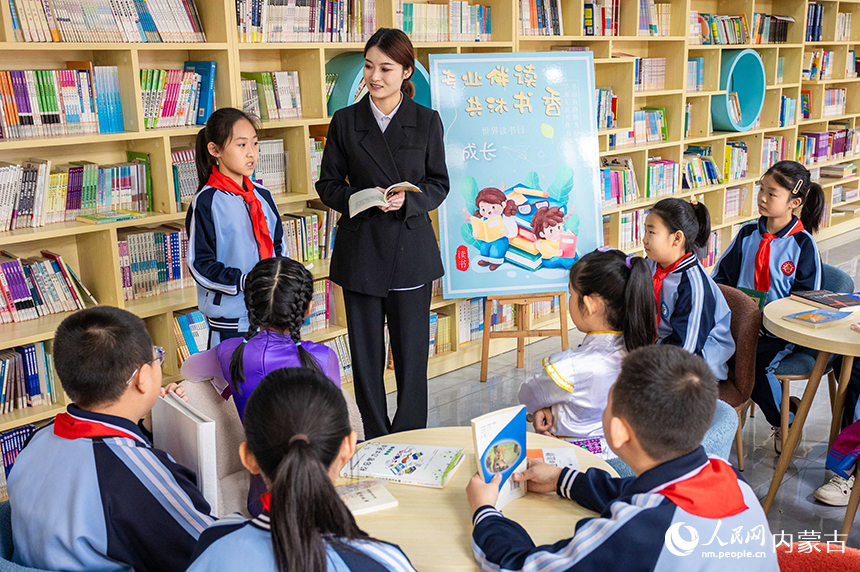 呼和浩特市玉泉区南柴火市街小学学生在校园图书馆内向伙伴们分享读书心得。丁根厚摄