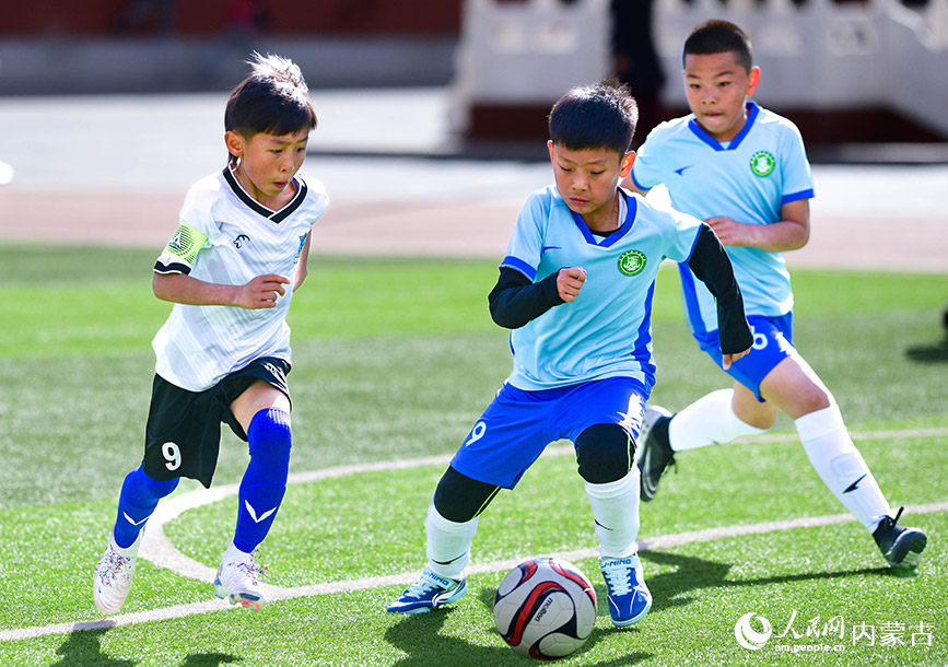 4月21日，呼和浩特市赛罕区昭乌达路小学队球员王扬子淇（中）在比赛中带球。王正摄