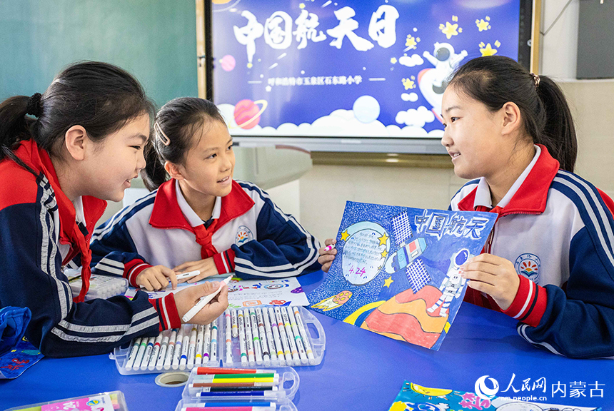呼和浩特市玉泉區石東路小學學生在中國航天日主題科普活動中展示創作的太空畫。丁根厚攝
