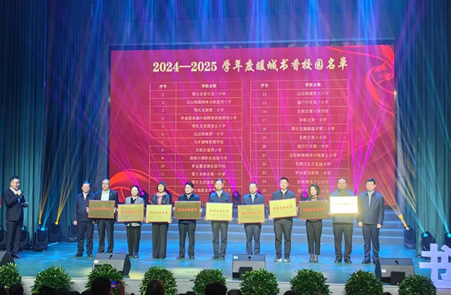 为各旗区代表颁发2024-2025学年度暖城书香校园奖牌。