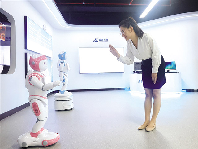 內蒙古和林格爾新區人工智能體驗館工作人員與人工智能機器人溝通。王劭凱 攝