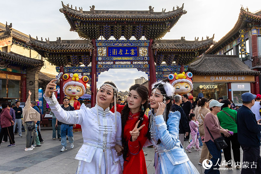 5月1日，旅拍游客在第六届塞上老街音乐美食季活动现场打卡拍照。丁根厚摄