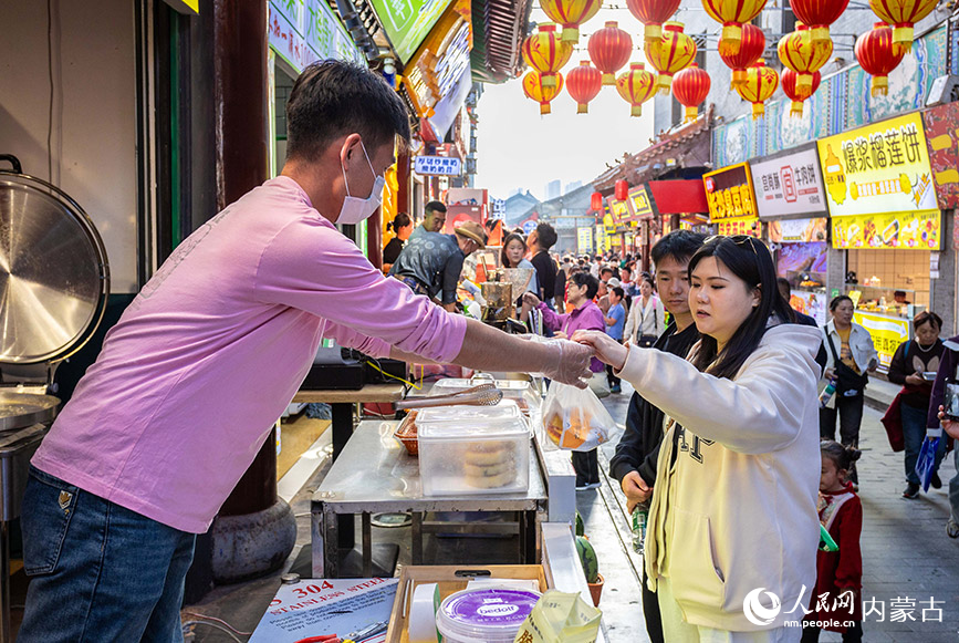5月1日，游客在第六届塞上老街音乐美食季夜市街区选购特色小吃。丁根厚摄