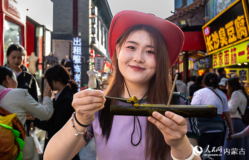 5月1日，游客在第六届塞上老街音乐美食季夜市街区品尝特色小吃。丁根厚摄