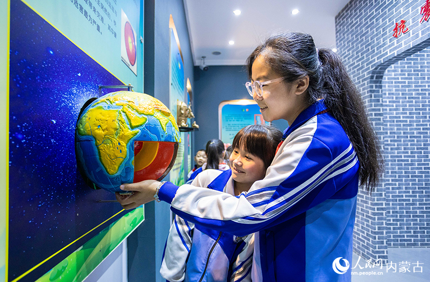 內蒙古呼和浩特市玉泉區通順街小學學生在地震科普館裡通過模型了解地球內部構造。丁根厚攝