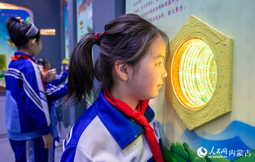 內蒙古呼和浩特市玉泉區通順街小學學生在地震科普館裡通過模型了解地震前兆知識。丁根厚攝