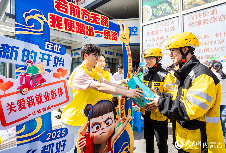 社工志願者在呼和浩特市玉泉區“‘新’心攜手 基層共治”游園會活動現場為外賣員送上暖心禮包。丁根厚攝
