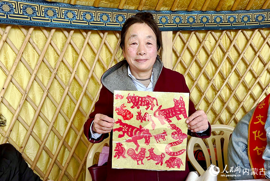 非物質文化遺產代表性傳承人展示十二生肖剪紙作品。實習生 劉瀛攝