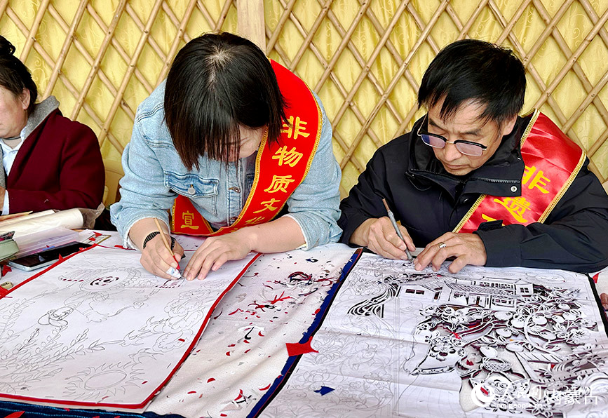 非物质文化遗产代表性传承人制作剪纸作品。 实习生 刘瀛摄