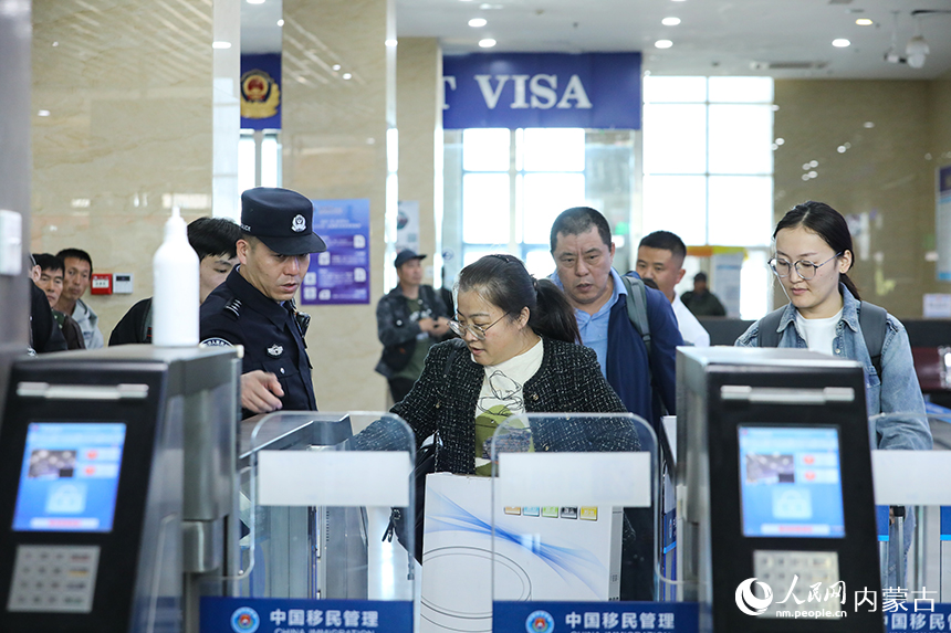 二连出入境边防检查站移民管理警察协助旅客从快捷通关快速通关。郭鹏杰摄