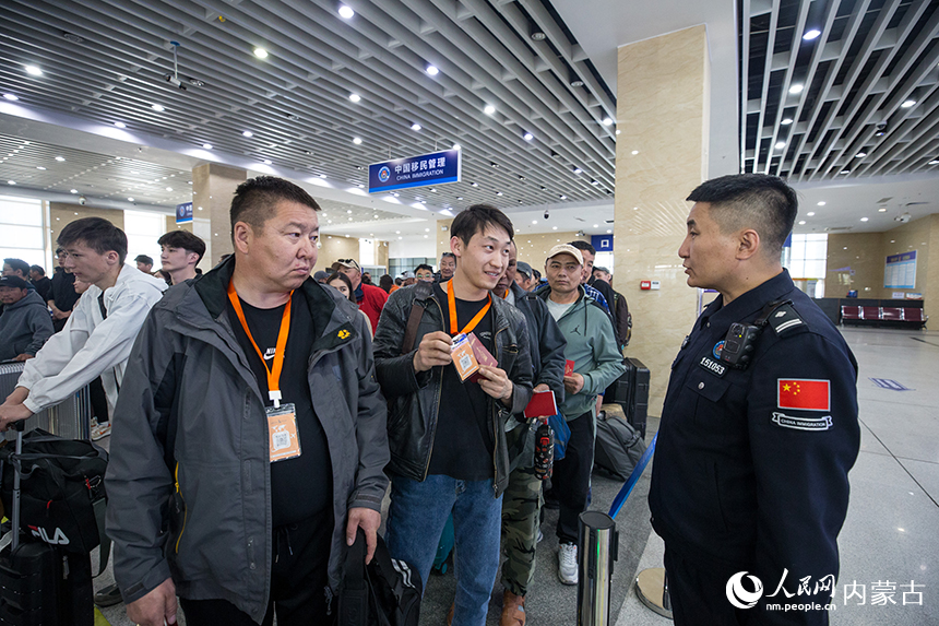 二连出入境边防检查站移民管理警察为旅客提供通关咨询。郭鹏杰摄
