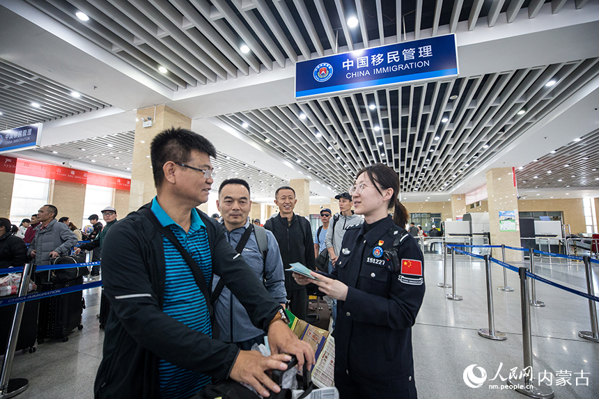 二连出入境边防检查站移民管理警察为旅客提供通关咨询。郭鹏杰摄
