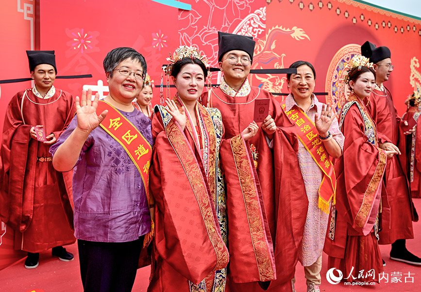 儀式現場，新人手持結婚証與自治區道德模范合影留念。實習生 賈志紅攝