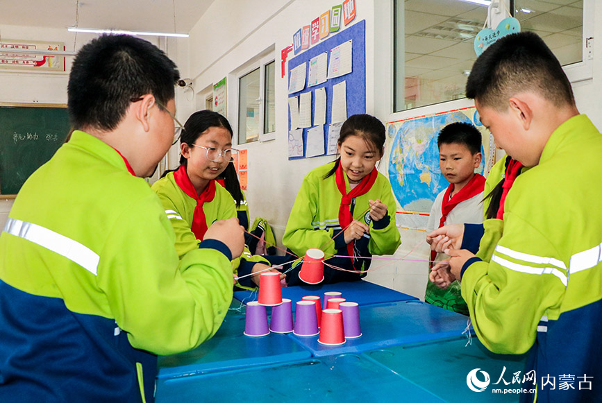 5月23日，呼和浩特市玉泉区青少年宫“流动少年宫”公益专列校园活动现场，学生在心理团辅互动成长《我们一起玩》课上做游戏。丁根厚摄