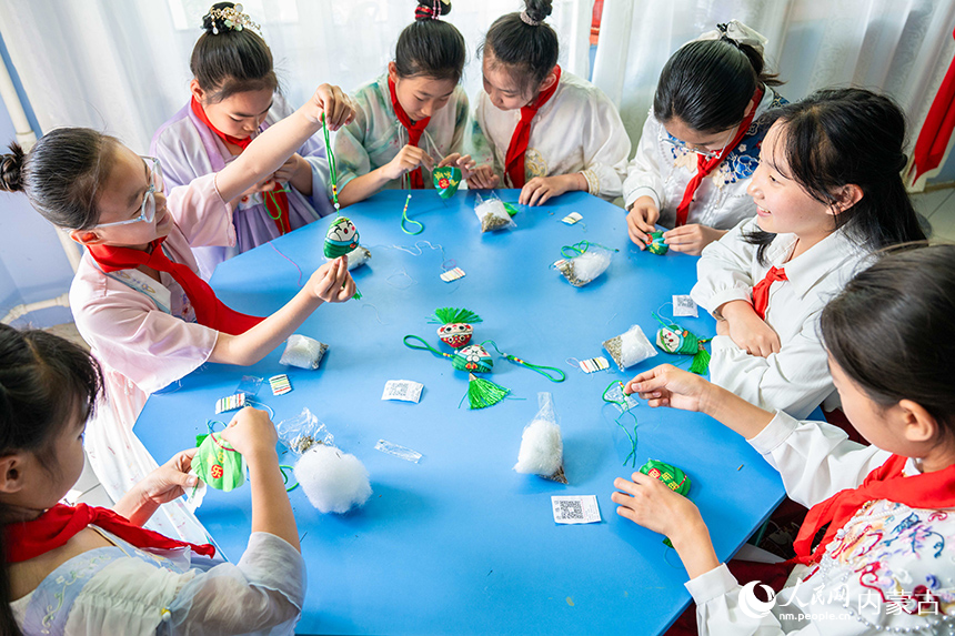内蒙古呼和浩特市玉泉区恒昌店巷小学学生在“缤纷端午 粽享童趣”主题活动现场体验制作香囊。丁根厚摄