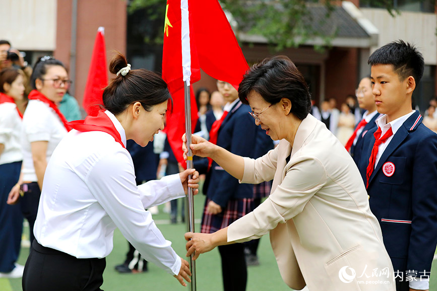 学校领导为新建中队授旗。人民网记者 李睿摄