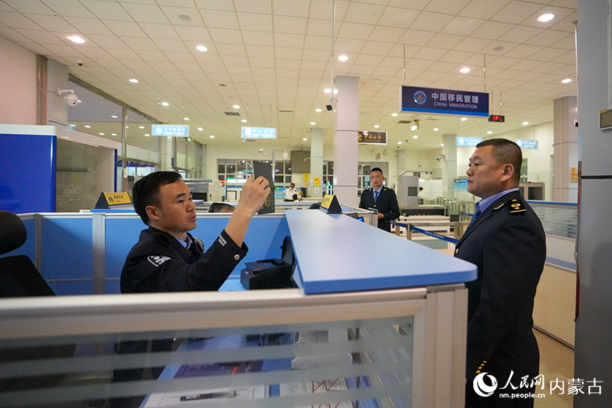 二连出入境边防检查站移民管理警察正在验放列车工作人员。杨金烨摄