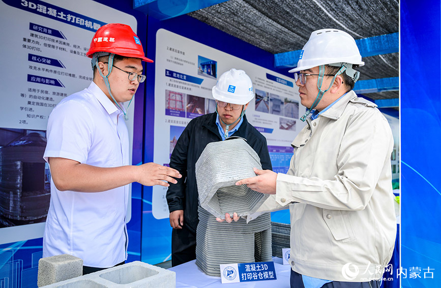 6月16日，參會人員在全國住房和城鄉建設領域“安全宣傳咨詢日”活動現場了解3D混凝土打印機器人打印的谷倉模型。丁根厚攝