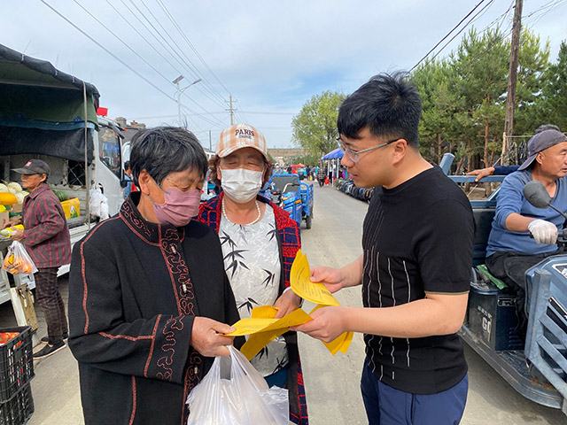 志愿者正在为群众宣讲社保政策