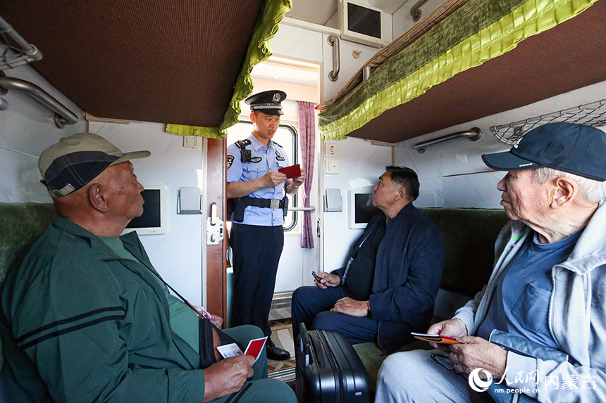二连出入境边防检查站移民管理警察在入境列车上查验蒙古国患者的证件。杨金烨摄
